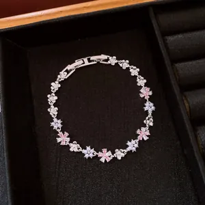 Detailed view of silver flower bracelet with pink zircons and pearls on black tray