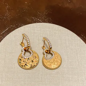 Detail of 18k gold plated hollow gourd earrings with sparkling zircon stones.