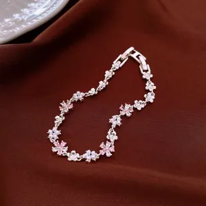 Close-up detail of silver-tone floral bracelet with pink crystals and small pearls