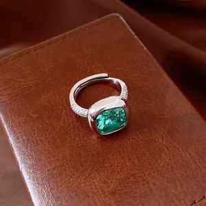 Détail macro d'une bague ajustable vintage avec zircon vert sur fond en cuir brun