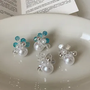 Detailed macro view of elegant pearl flower earrings with blue and clear zircon crystals