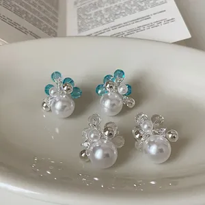 Detailed view of floral pearl stud earrings with sparkling cubic zirconia accents