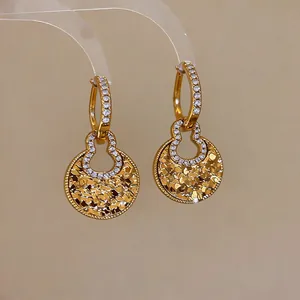Detailed macro view of 18k gold-plated hollow gourd earrings encrusted with sparkling zircons.