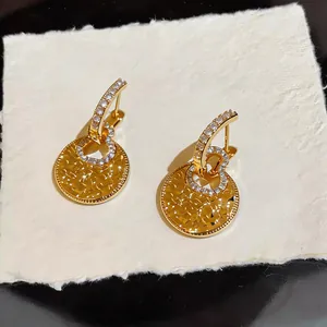 Detailed view of 18k gold-plated gourd earrings featuring hammered texture and zircons