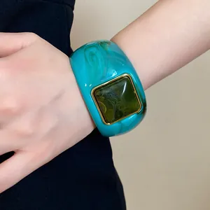 Close-up of a chunky turquoise marble acrylic bracelet with a square green resin inlay