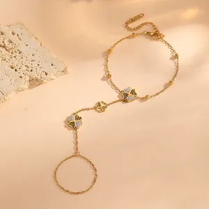 Vue détaillée d'un bracelet de main en acier doré avec motif papillon et cœur