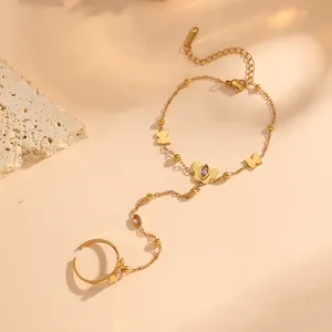 Vue détaillée du bracelet papillon doré avec gemmes roses et chaîne en acier titane.
