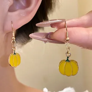 Cute yellow enamel pumpkin drop earrings for a sweet and stylish autumn look.