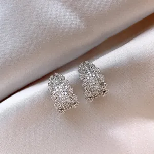 Dettaglio di orecchini a lobo a forma di C color argento con cristalli incastonati