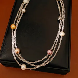 Elegante collana di perle a più strati con perle colorate su una scatola di gioielli nera