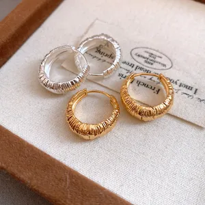 Vista macro dettagliata di eleganti orecchini a cerchio vintage in finitura oro e argento