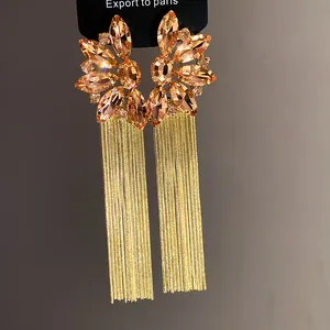 Detailed view of elegant champagne crystal flower top with long gold chain tassels