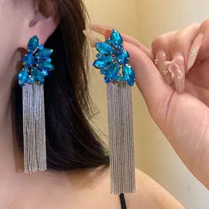 Macro view of blue crystal flower tassel earrings with long silver-tone chains