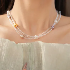 Dettaglio ravvicinato di un elegante collana a più fili con perle colorate sul collo