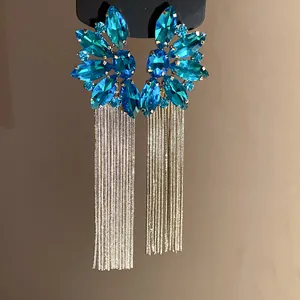 Detailed view of silver needle tassel earrings with blue floral crystal clusters