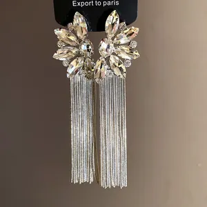 Detailed view of elegant rhinestone flower earrings with long silver tassel chains.