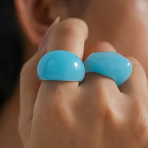 Macro detail of sky blue chunky resin rings with a glossy semi-translucent finish