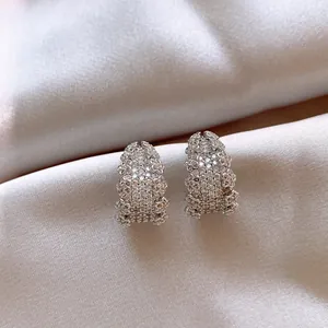 Primo piano dettagliato di eleganti orecchini a forma di C decorati con strass