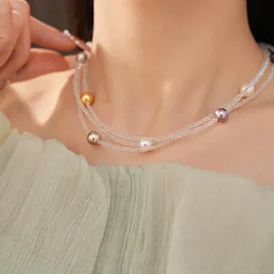 Primo piano di una collana di perle a più strati con perle colorate su una modella