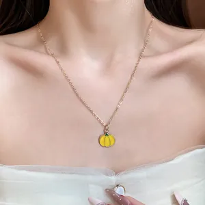 Sweet yellow oil-drop pumpkin pendant necklace worn on model neck for a fresh chic look