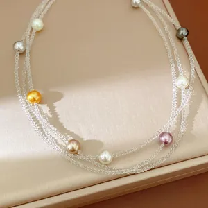 Vista dettagliata di un'elegante collana a più fili con perle trasparenti e colorate