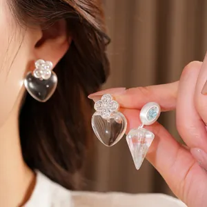 Detailed shot of transparent heart and cone resin earrings with ice blue stone