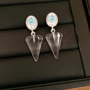 Close-up of elegant ice blue drop earrings with transparent cone resin pendants
