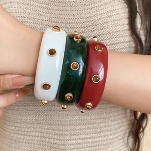 Detailaufnahme von Vintage-Resin-Armreifen mit Marmortextur und dekorativen Nieten