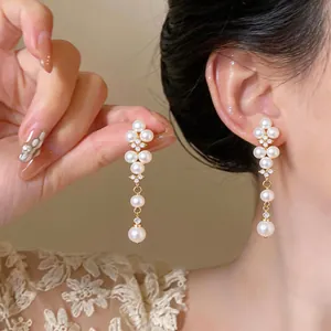 Close-up view of elegant French style drop earrings featuring pearls and zircons for women