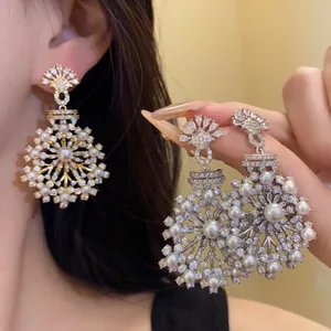 Gros plan sur d'élégantes boucles d'oreilles fleurs en perles et zircons sur une mannequin