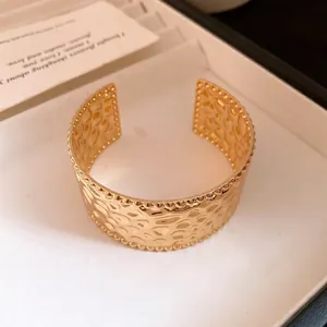 Eleganter vergoldeter Armreif mit Hammerschlag-Muster und Perlenrand in einer Schmuckbox