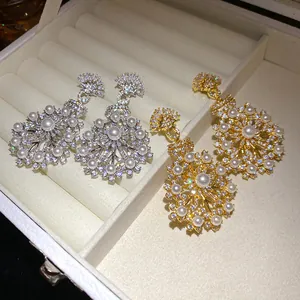 Vue détaillée de boucles d'oreilles ornées en perles et cristaux dorés et argentés