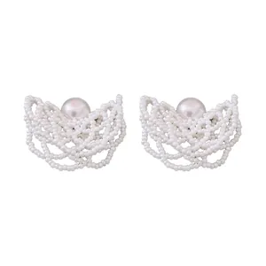 Eleganti orecchini a lobo in perle bianche intrecciate con raffinato design traforato.