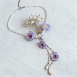 Elegante collana con fiori di stoffa viola, nappe e accenti di perle bianche