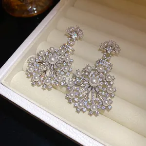 Gros plan détaillé sur d'élégantes boucles d'oreilles florales avec zircons et perles