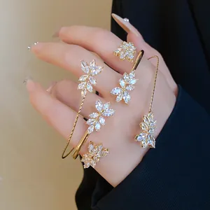 Detail of golden wheat ear bracelet with marquise-cut zircons and matching rings
