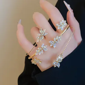 Close-up of sparkling zircon wheat ear bracelets and rings set on hand