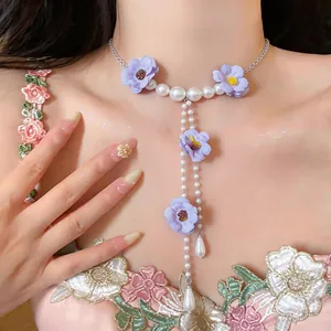 Dettaglio collana girocollo coreana con fiori di stoffa viola e perle bianche lucide