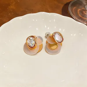 Macro view of geometric 18k gold plated stud earrings with sparkling faceted zircons
