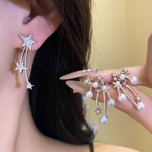 Dettaglio degli orecchini a stella in argento con strass scintillanti e perle bianche