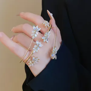 Detailed view of luxury gold bracelets with sparkling zirconia wheat ear design on hand.