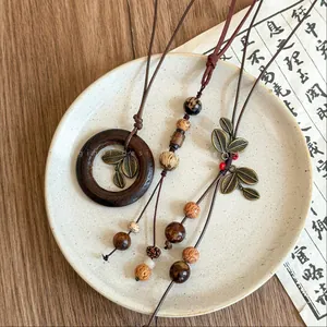 Detailed macro view of vintage Bohemian necklaces with wooden beads and Bodhi seeds on a plate.