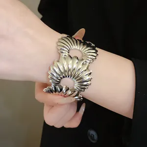 Detailaufnahme eines silbernen Armreifens mit Faltenstreifen am eleganten Handgelenk