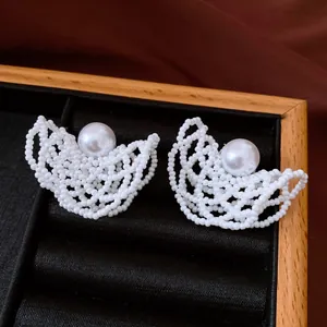 Eleganti orecchini a perno bianchi con perline e un raffinatissimo design traforato