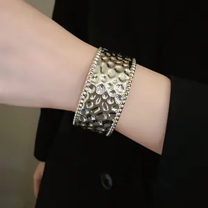 Detailansicht der gehämmerten Textur dieses eleganten silberfarbenen Metallarmreifs