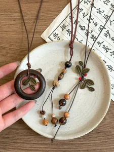 Detailed macro view of retro Bodhi seed and wood pendant necklaces on a ceramic plate