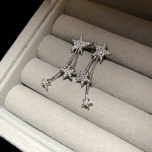 Primo piano di orecchini a stella d'argento con strass scintillanti incastonati