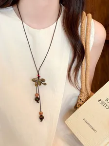 Close-up detail of ethnic style long necklace with vintage leaf pendant and bodhi beads