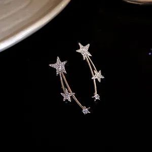 Dettaglio macro di orecchini a stella con strass scintillanti e ago in argento lucido