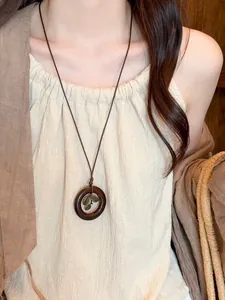 Vintage ethnic style circular bodhi pendant necklace with leaf charm detail on a female model